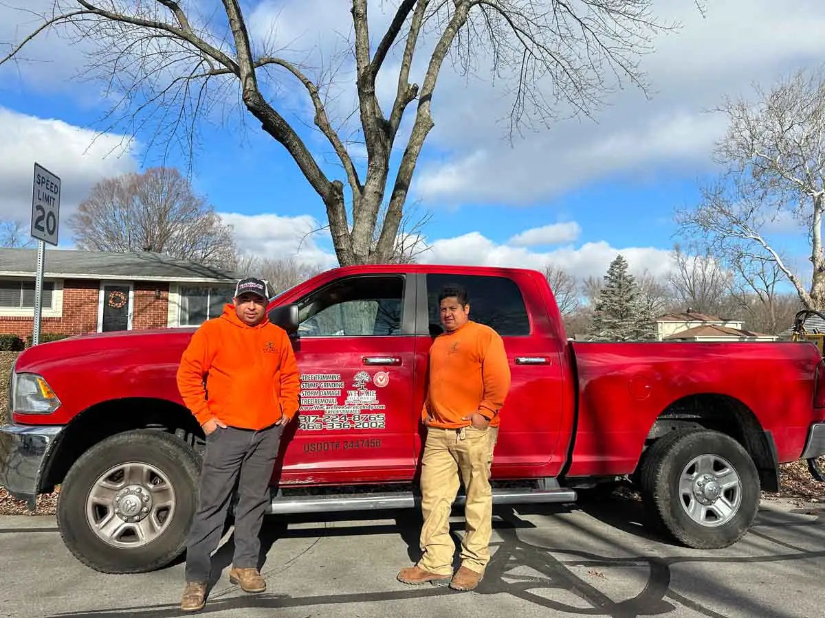 Two team members beside a company pickup truck in Indianapolis