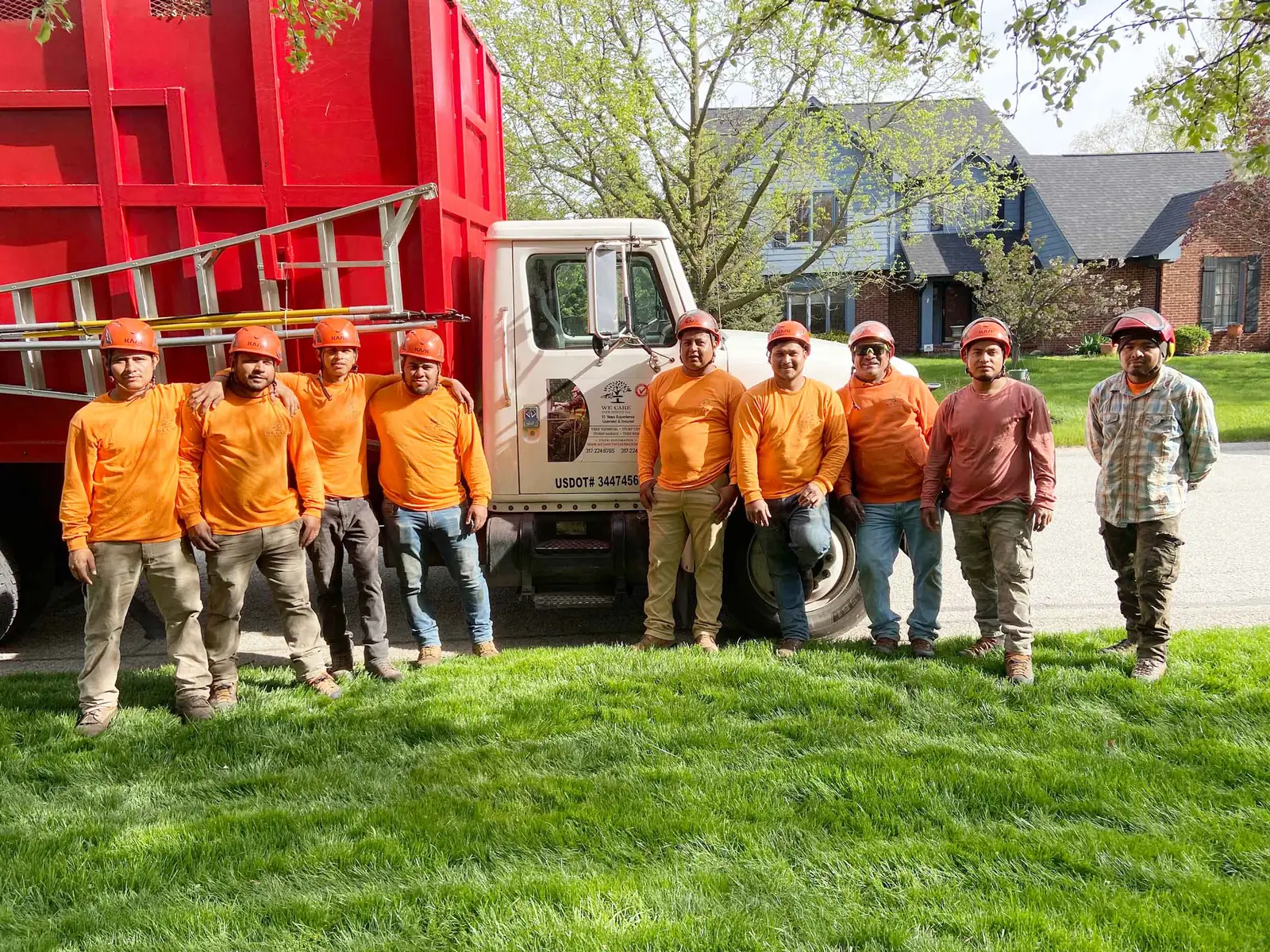 We Care Tree Service crew standing in front of their dump truck