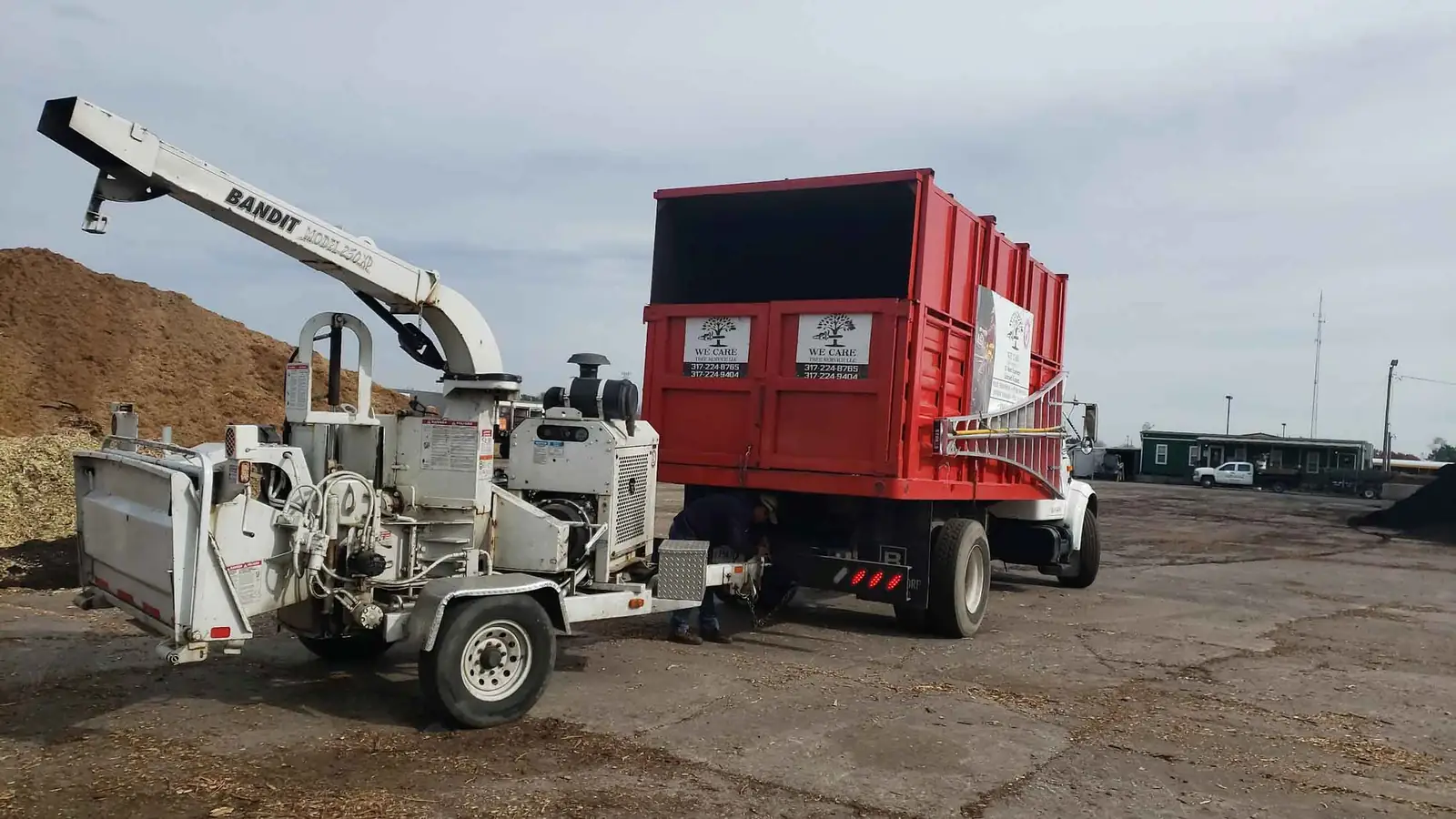 Wood chipper hitched to a red dump truck